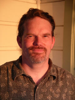 Photo of Jim in reddish sunlight with goofy grin